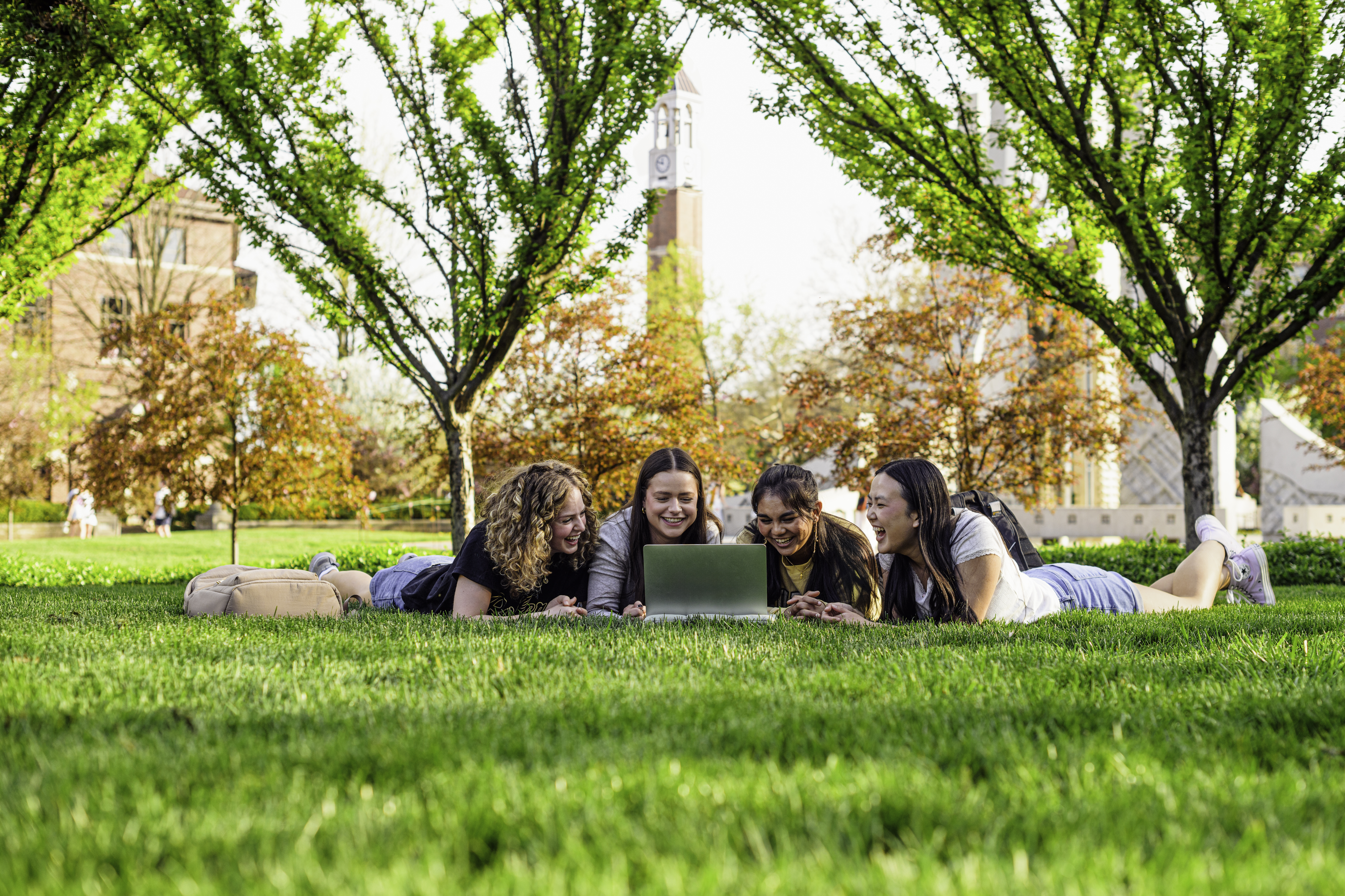 Students looking at a computer outside on campus. 