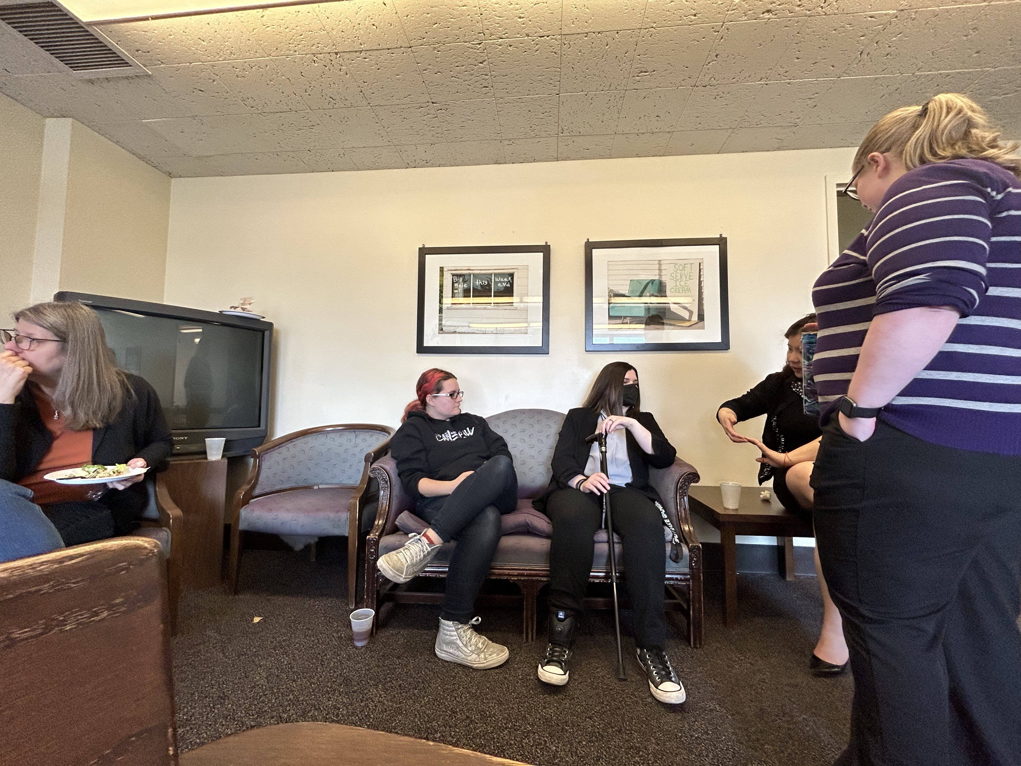 Five instructors sit in a lounge room in Heavilon Hall having a conversation