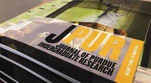 photograph of a stack of physical copies of the Journal of Purdue Undergraduate Research