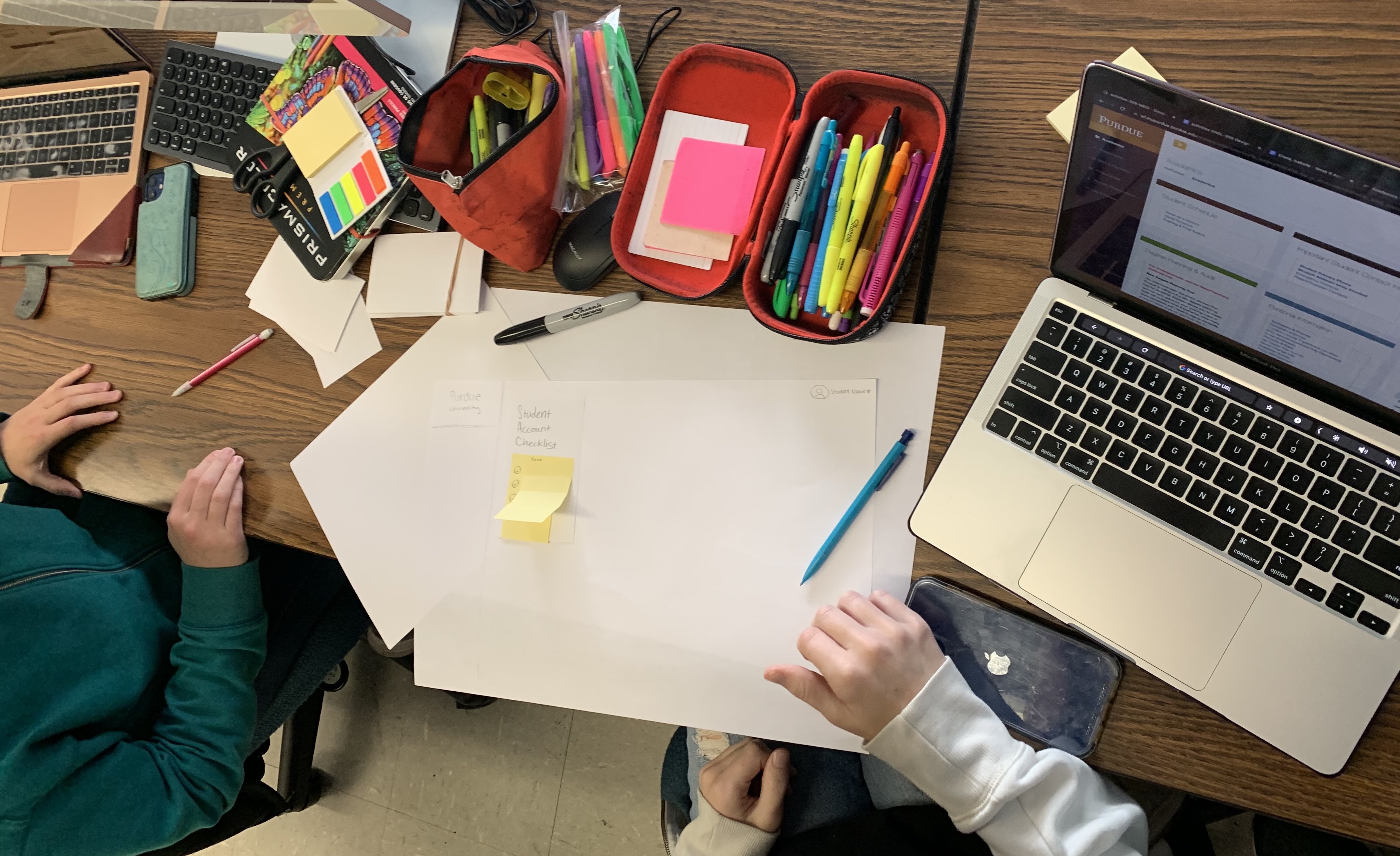 Group of two students working with physical and digital media.