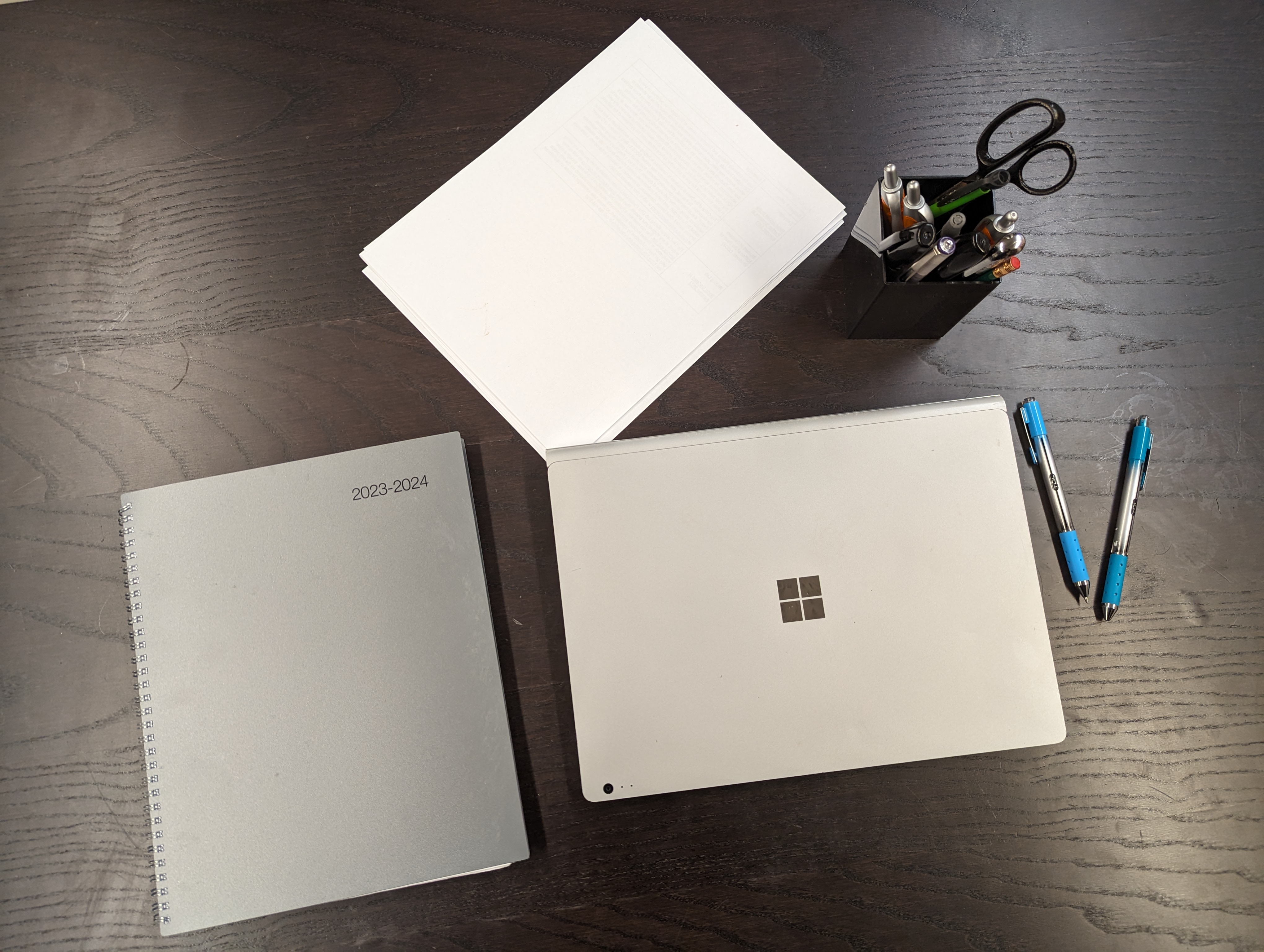 Tabletop with laptop and planner.