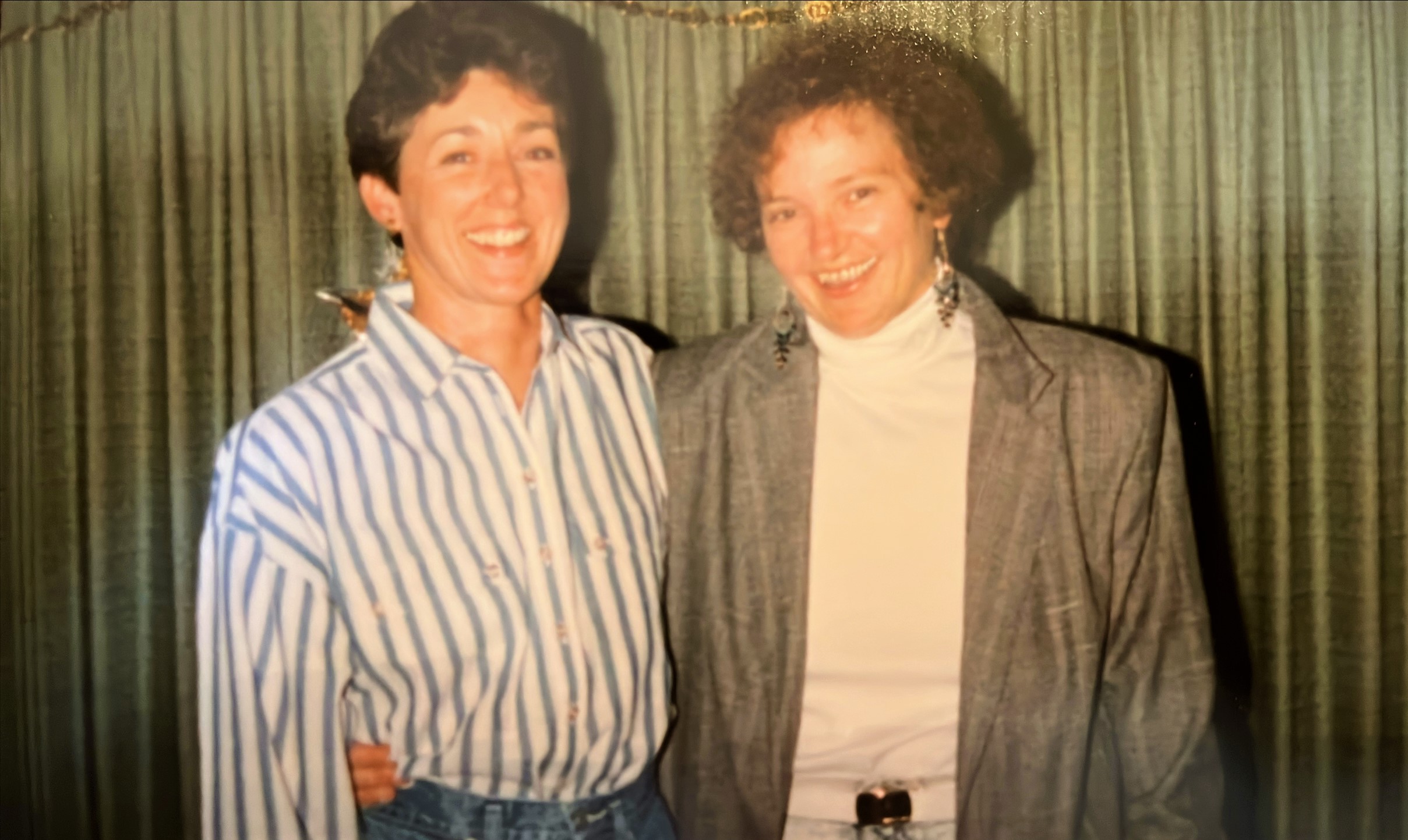 Sandra Crews (left) and Harriet Biggs (right) smile at the camera. Sandra's arm is around Harriet's waist; Harriet's arm is around Sandra's shoulder. 