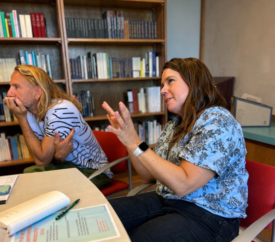 Two people in an office discussing an assignment.