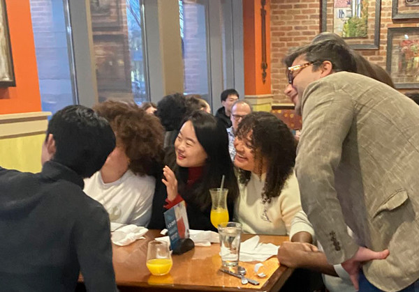 Students and faculty taking a photo together in a restaurant