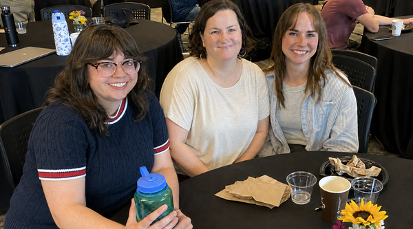 Graduate students sitting at a banquet table together.