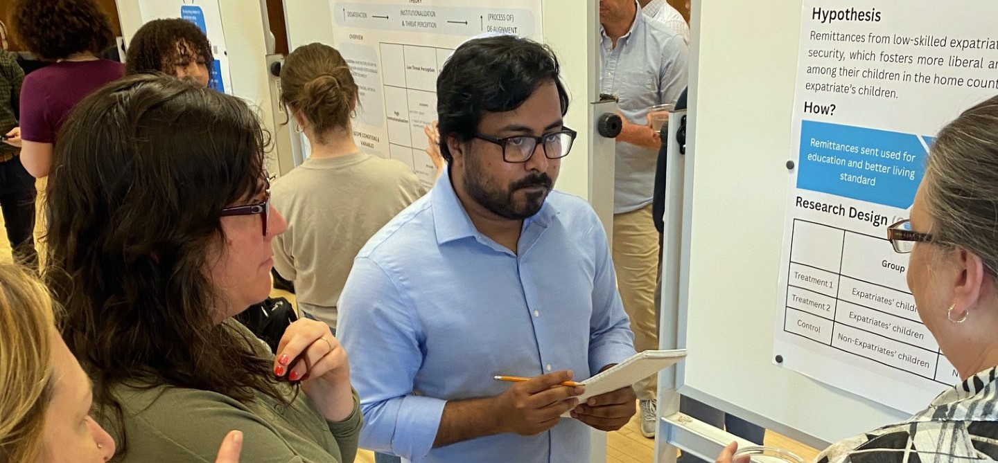 Graduate student presenting research at a poster session