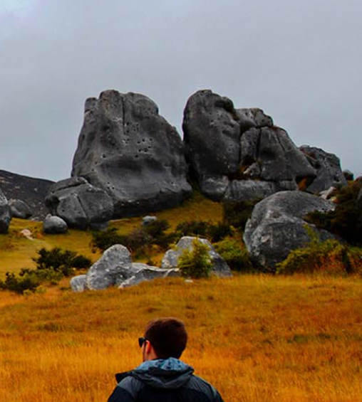 Student on a field approaching boulders