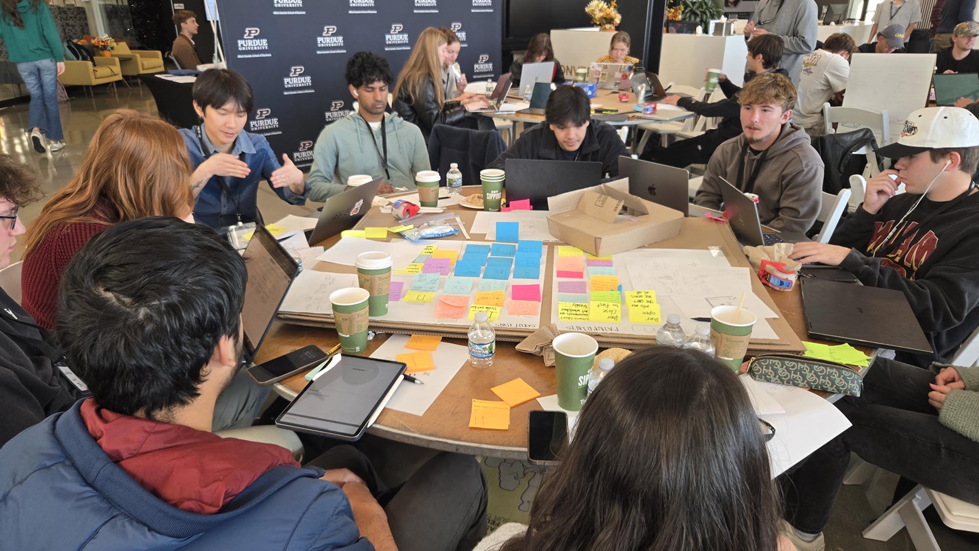 Students working to come up with ideas in large room. 