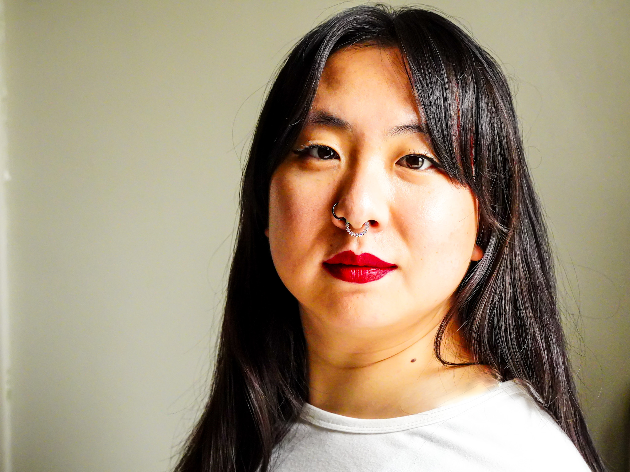 dancer squatting infront of a brick wall