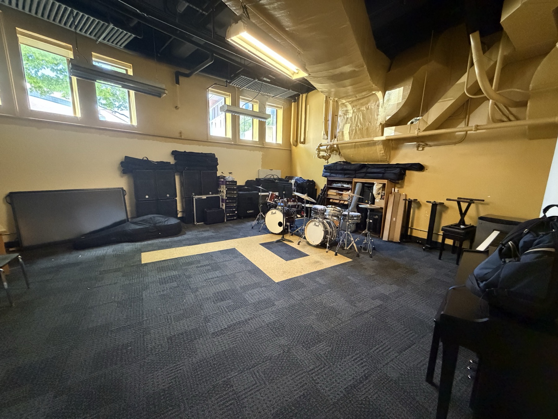 Elliott 31 ensemble practice room and tracking room with drums, audio equipment, and open floor space.
