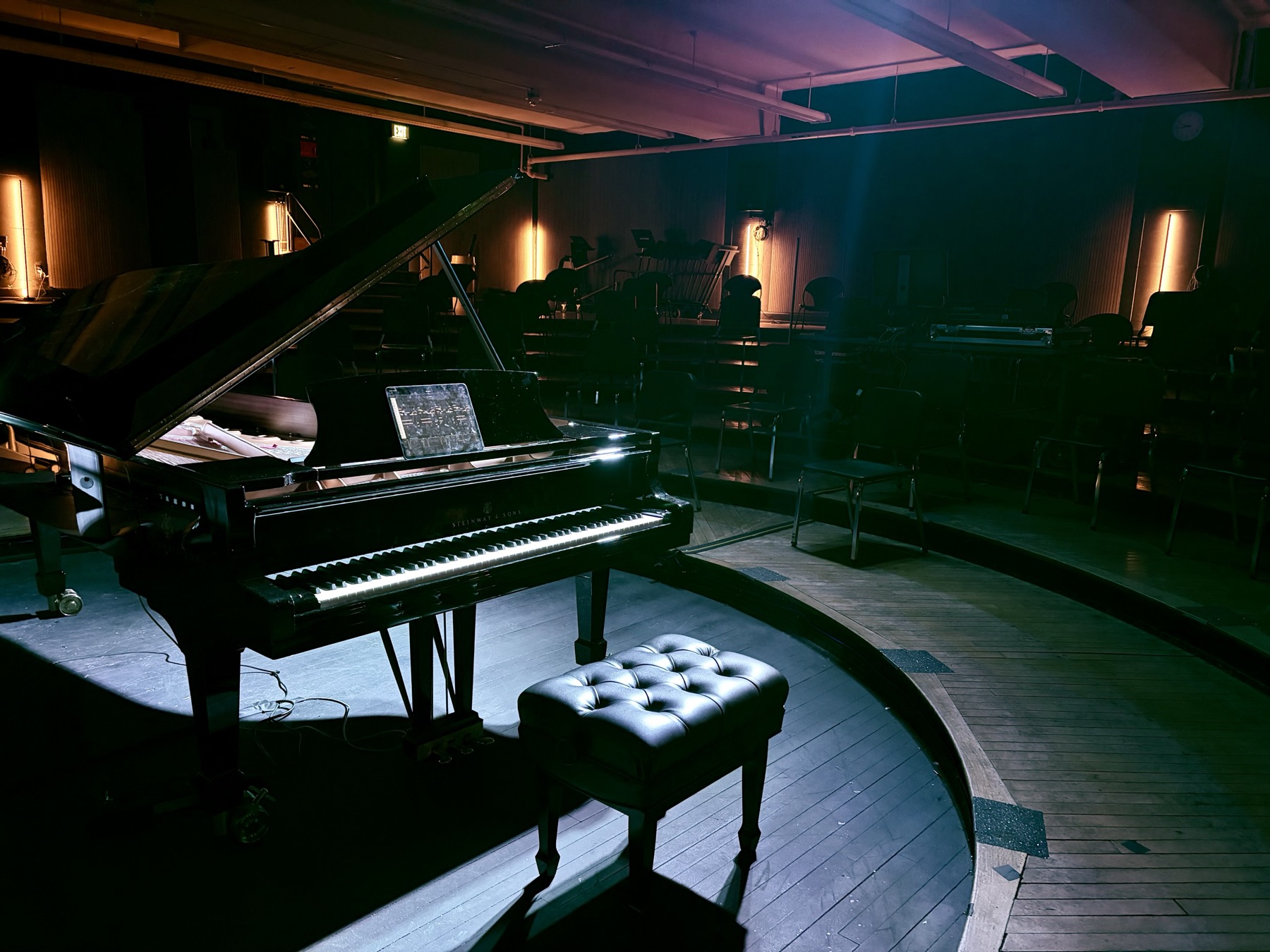 Steinway Spirio piano in Recital Hall with performance lighting and immersive audio setup.