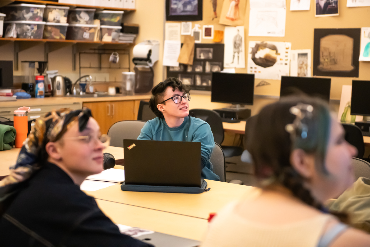 A student looks toward their instructor in a design classroom.