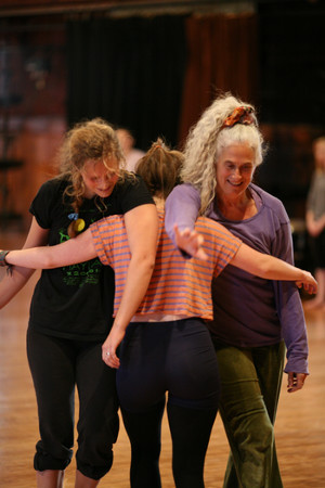 Ann Cooper Albright dancing with students. Interlocking arms.