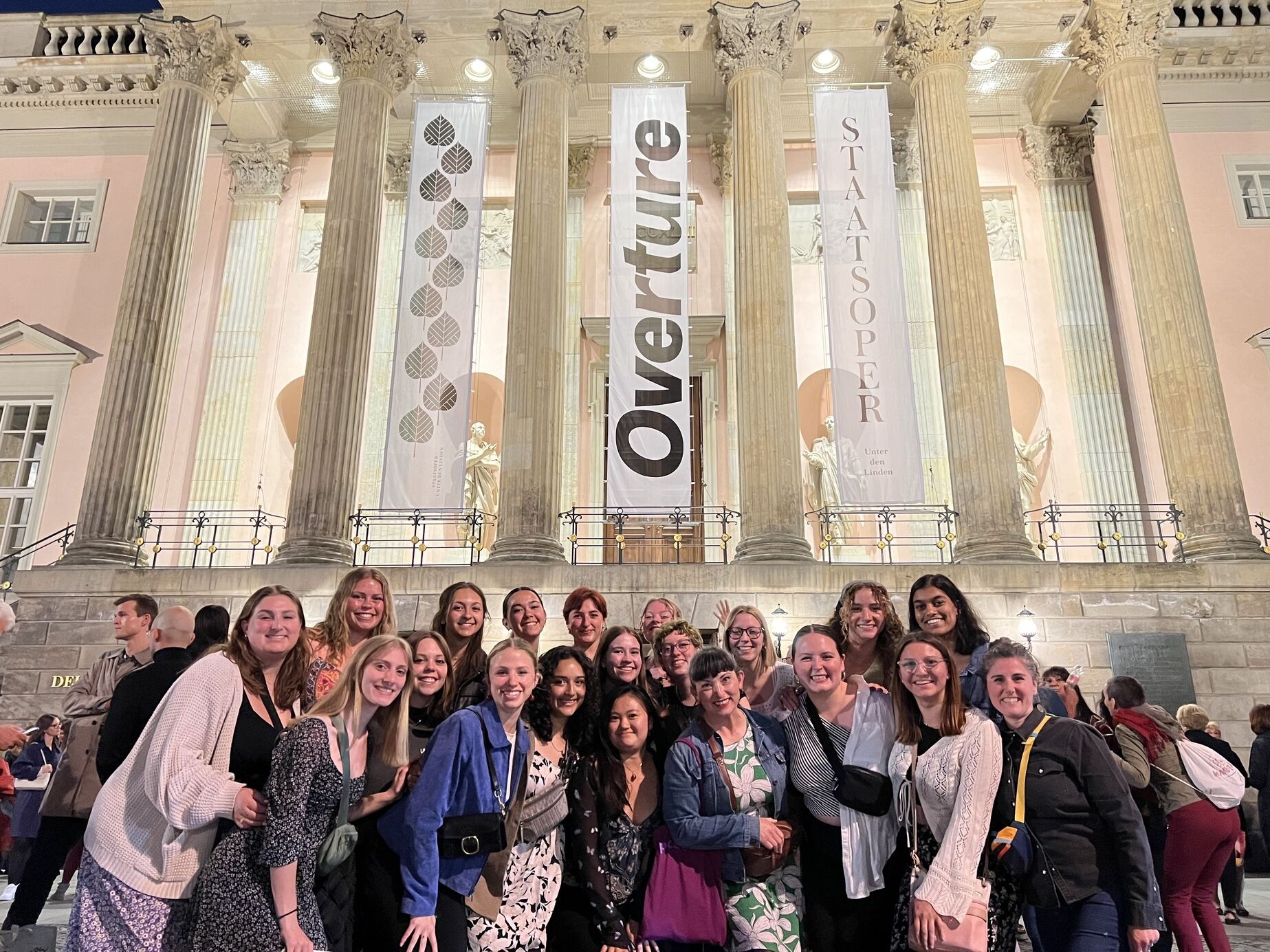 Group of dancers standing in front of a building.