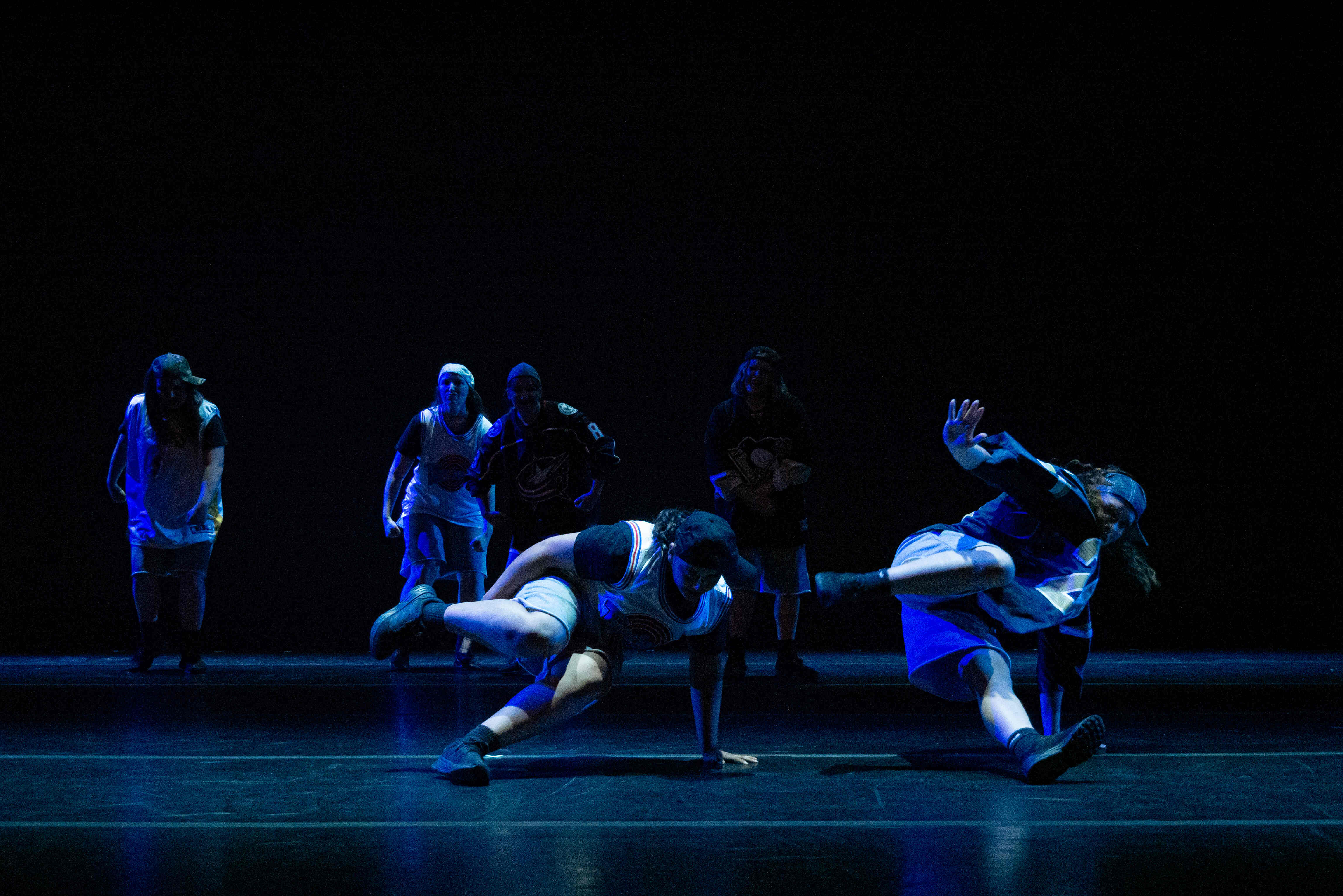 Dancers on stage on the floor.
