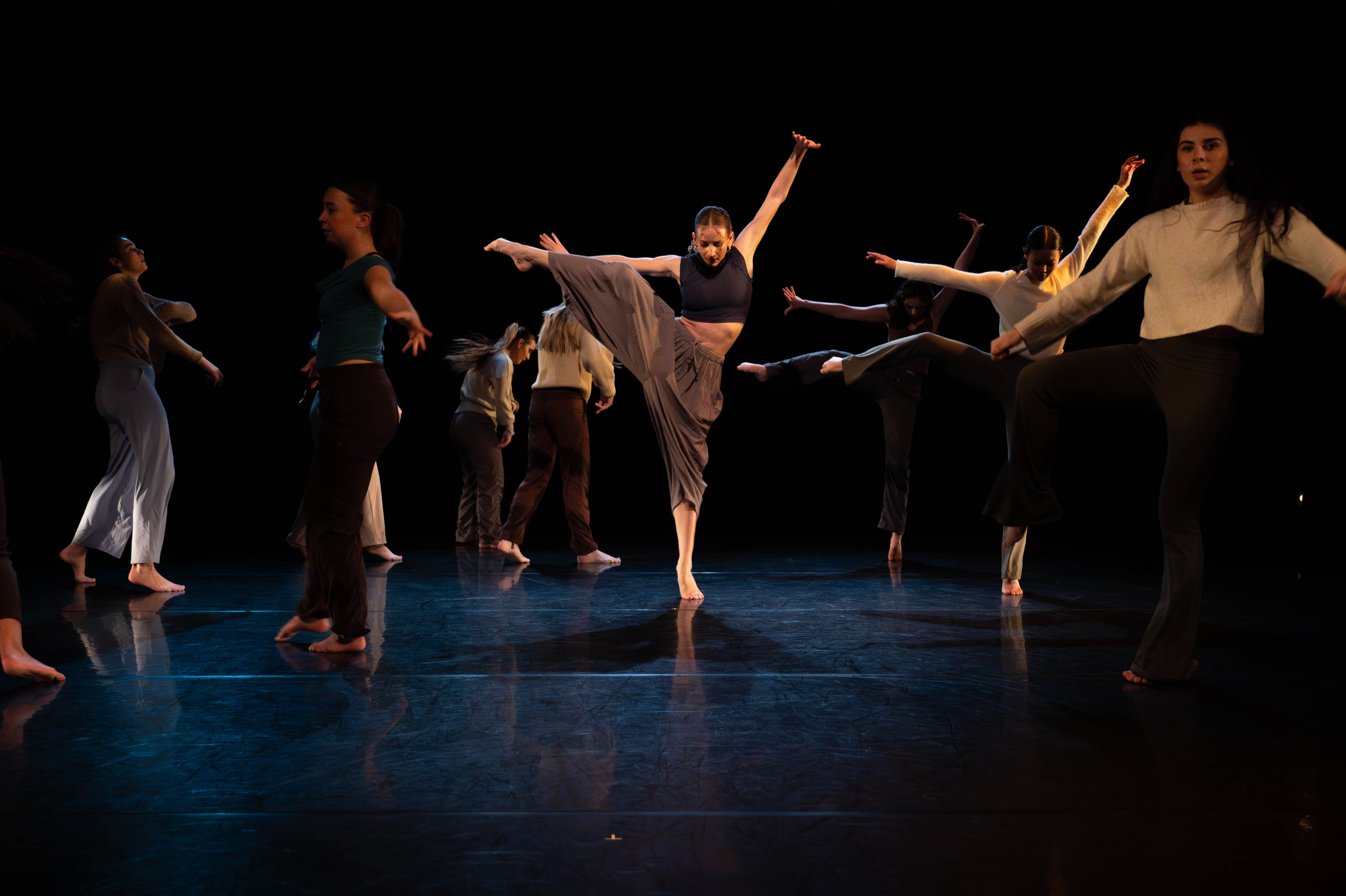 four dancers on stage. one dancer held with a bucket on their head.
