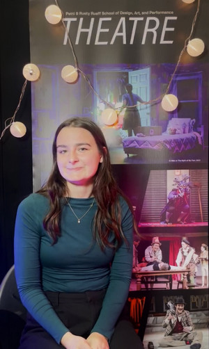 Elizabeth Zerfas sitting in front of a Theatre banner waiting to do her student interview.