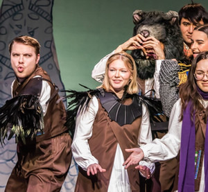 Elli Jones in a performance of THE SNOW is standing in a group looking off to the side.
