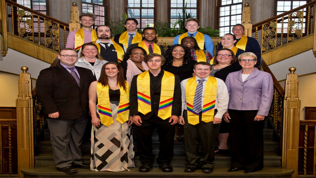lgbtq studies banner- many students from the lavender graduation standing on stairs