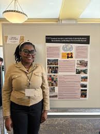 chinaza justina eeger standing in front or poster