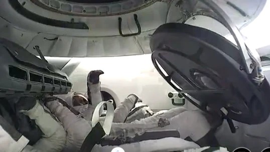 This photo captures a historic moment from the Polaris Dawn mission, featuring the interior of the SpaceX Dragon capsule during the world's first all-civilian spacewalk.