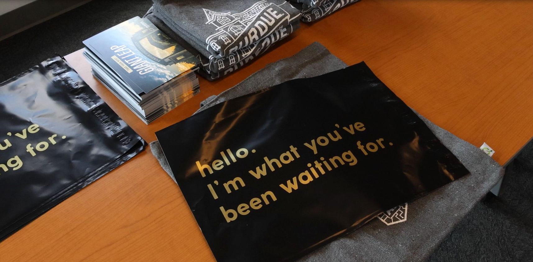 Various College of Liberal Arts marketing materials on a wooden table.