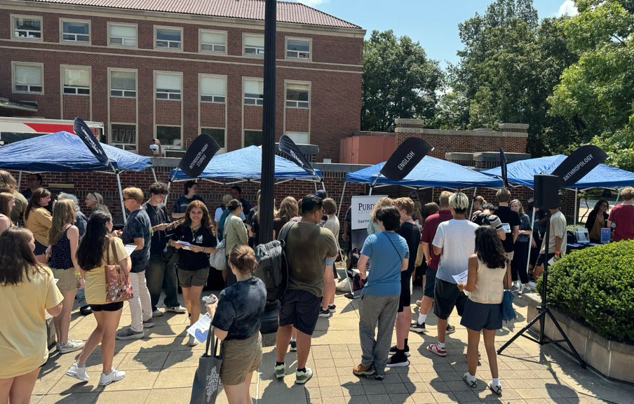 Students learning about different CLA majors at an event.