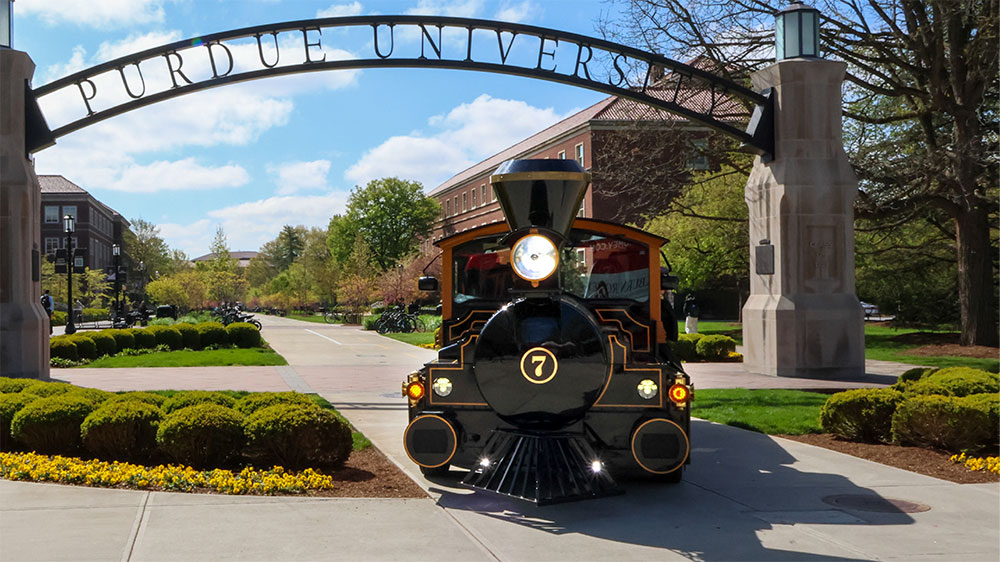 The Boilermaker Special train parked under an iron Purdue Boilermakers arched sign