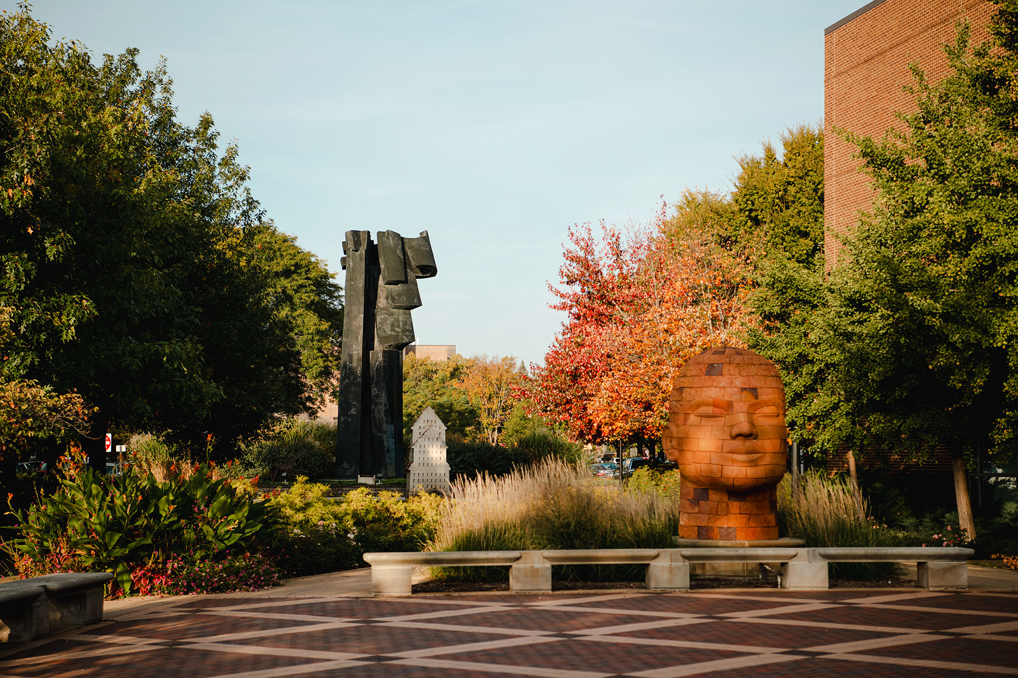 Statue of a large head in a grass garden
