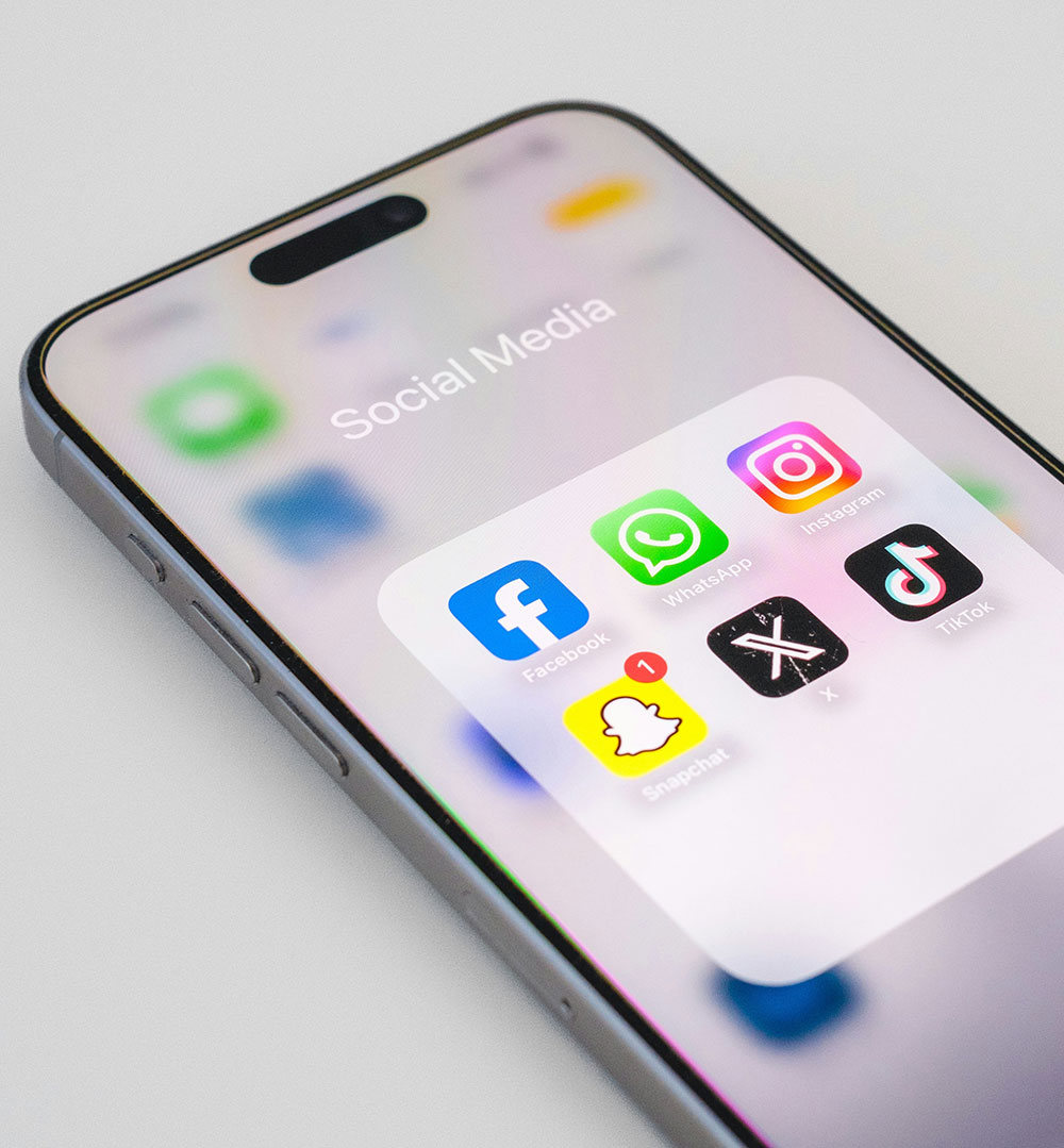 A smartphone that has a folder called Social Media with various social media app icons below it.