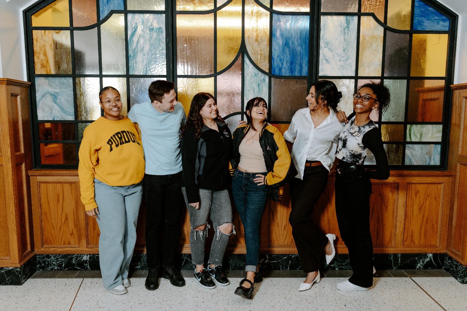 Students in a group pose, in the Purdue Union.