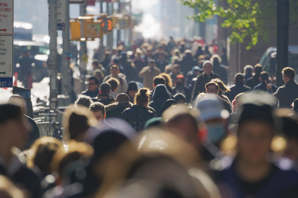A very large number of people walking along a street