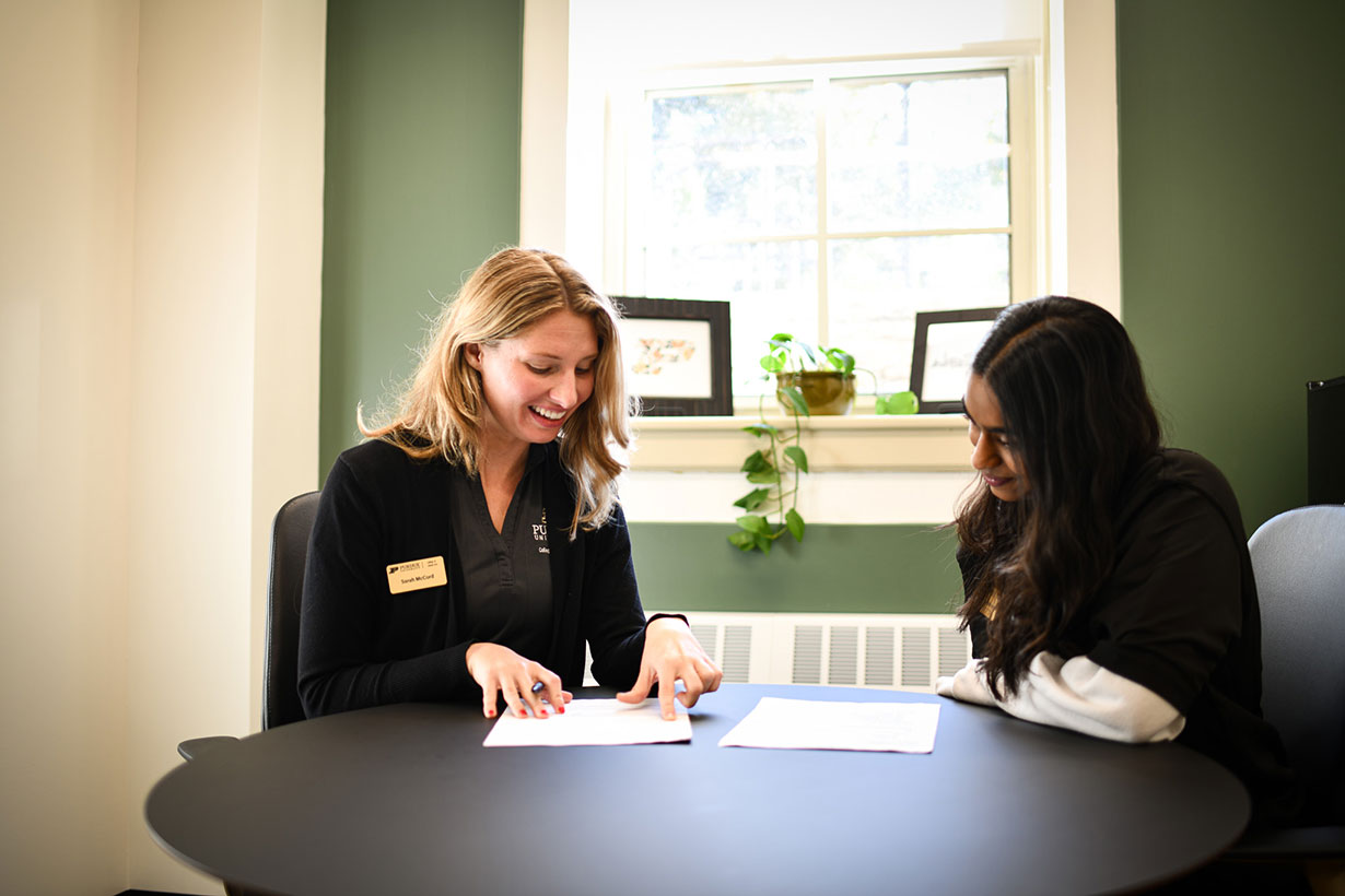 Careers specialist helping a student write a resume