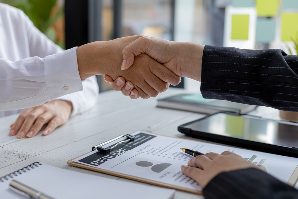 Two people shaking hands at a job interview